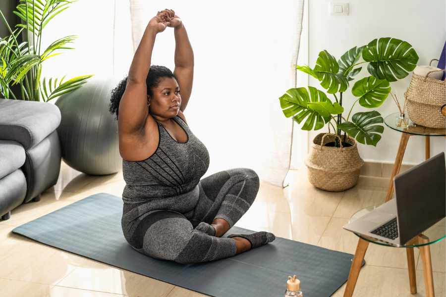 Woman exercising at home with laptop